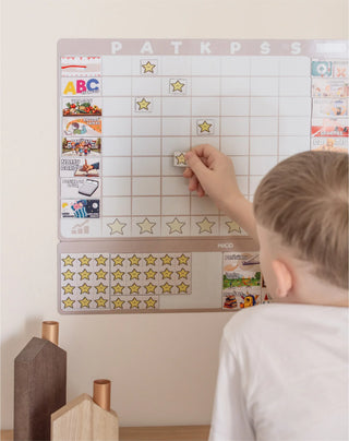 Vaikas žymi užduotis ant MAGO ugdymo lentos vaikams